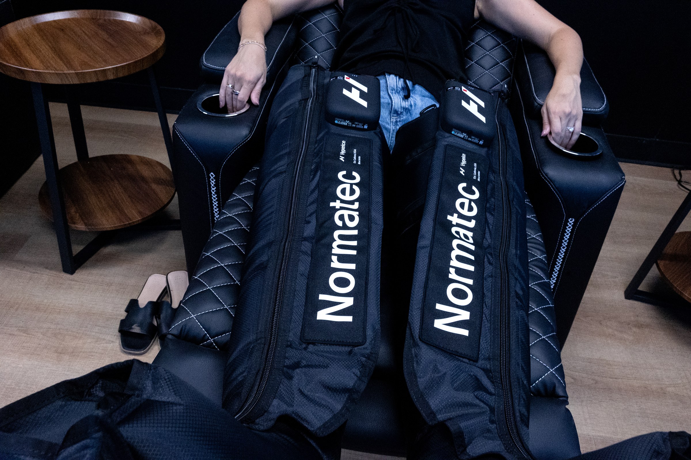 A member recovering in Normatec compression boots at Wellth
