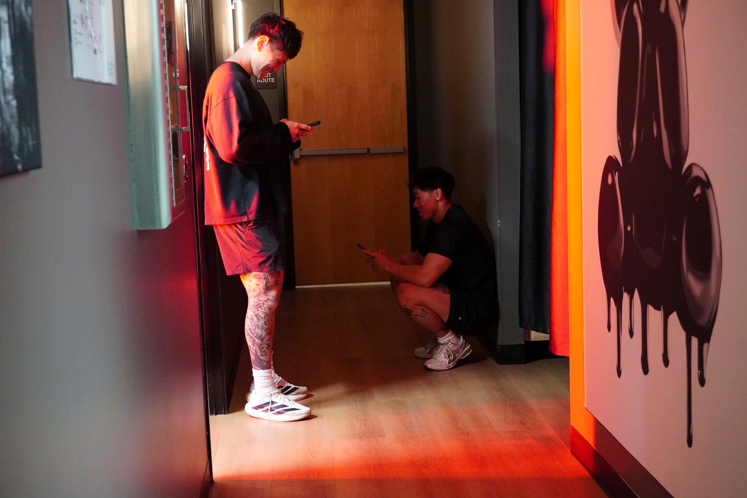 Two members catching up in the hallway between private suites at Wellth